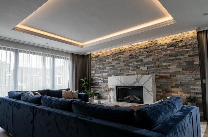 Corniches LED en plafond dans un salon contemporain avec canapé en velours marine